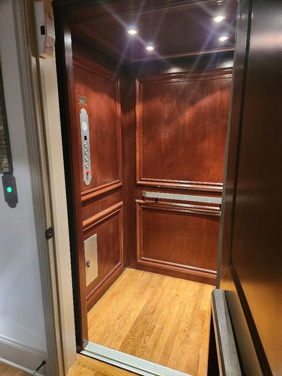 Details featuring light hardwood / wood-style flooring and elevator