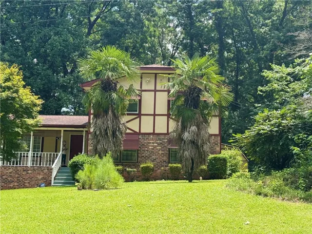 Two-story property featuring a brick lower level and Tudor-style half-timbering on the upper level