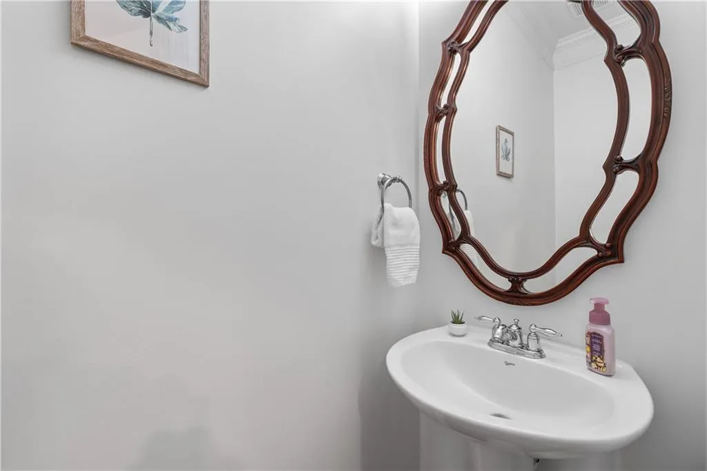 Bathroom featuring a sink and crown molding