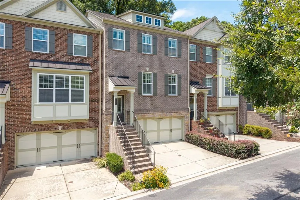 View of front of house with stairs, concrete driveway, a garage, and brick siding