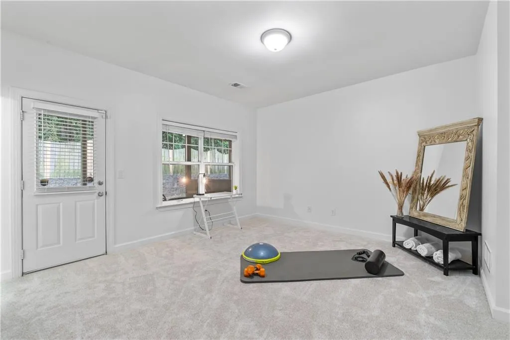 Exercise room featuring carpet flooring and baseboards