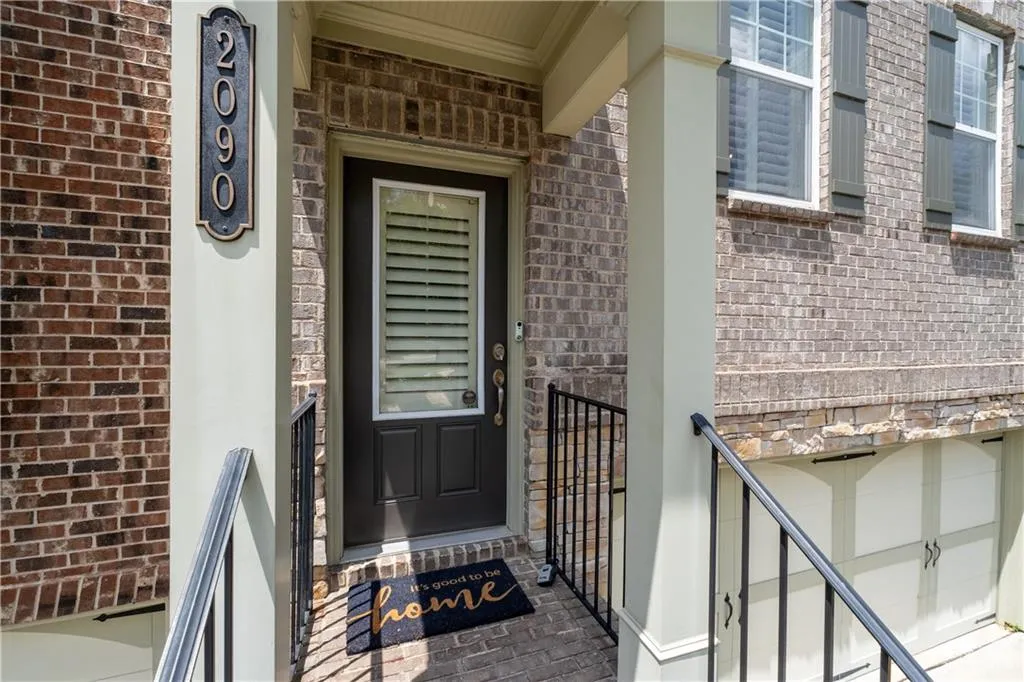 Entrance to property featuring brick siding and a garage