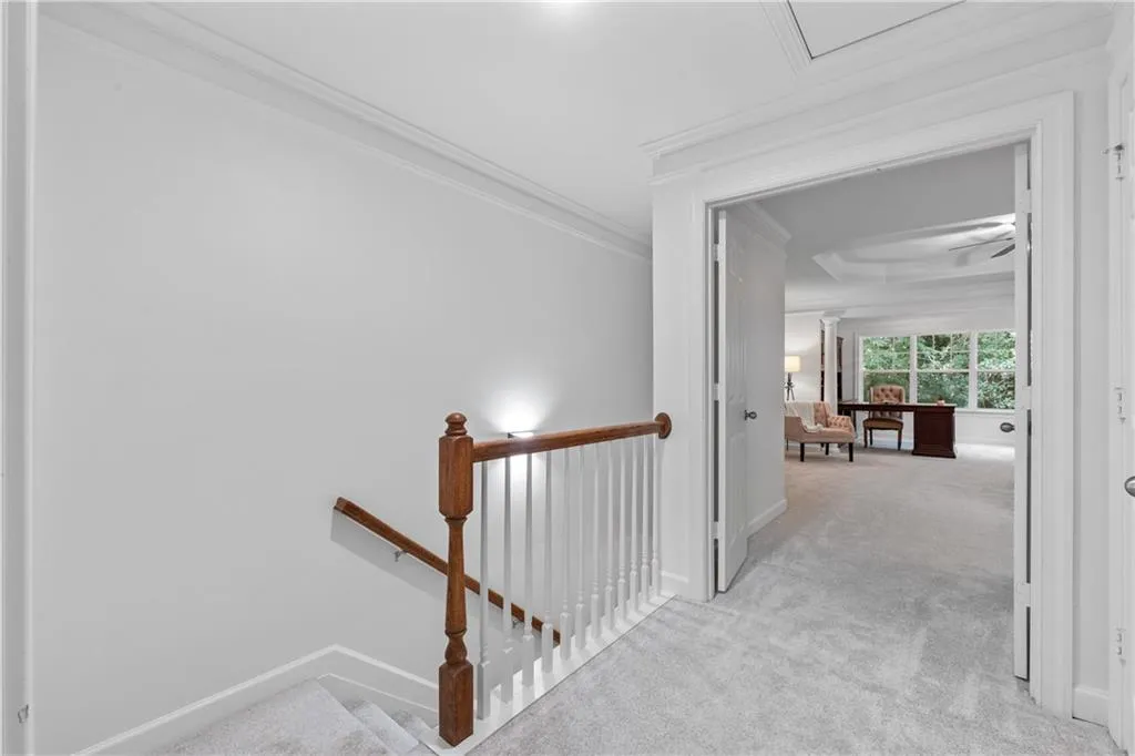Hall featuring ornamental molding, carpet flooring, and an upstairs landing