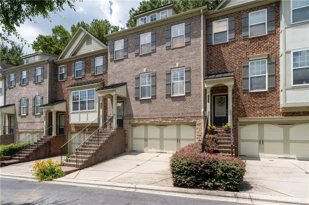View of front of house featuring concrete driveway, brick siding, and an attached garage