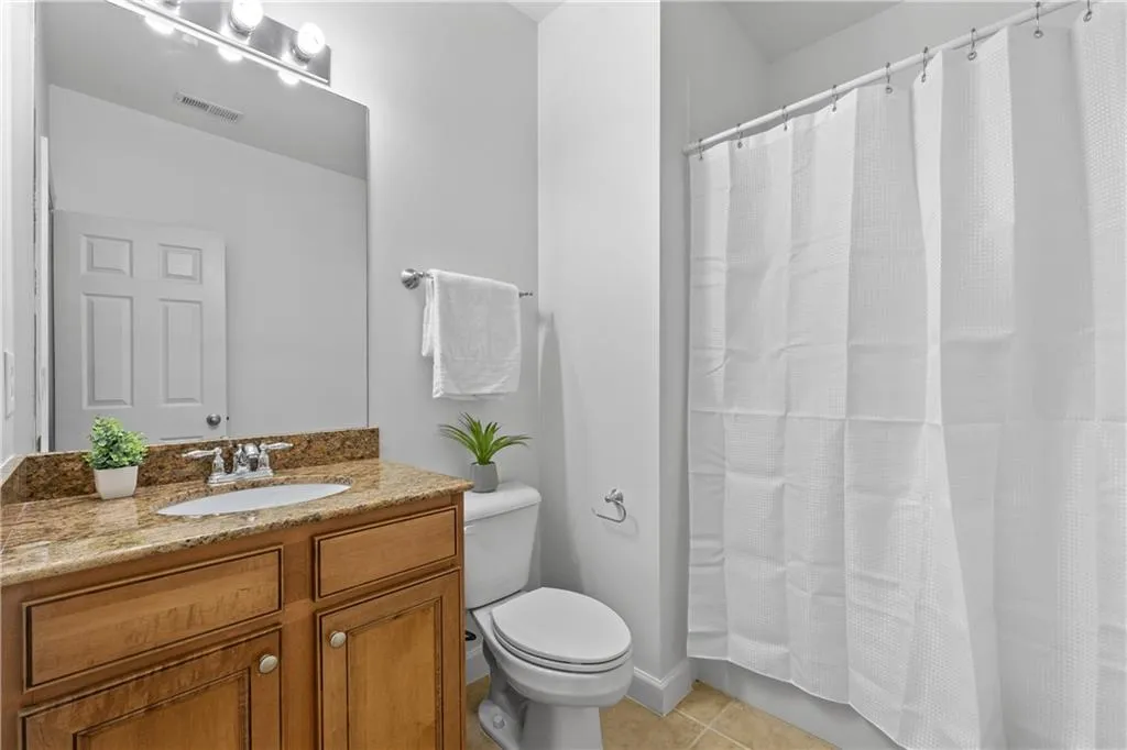 Bathroom featuring vanity, tile patterned flooring, and a shower with curtain