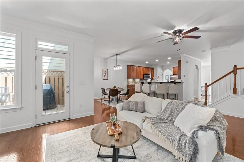 Living area with ornamental molding, a ceiling fan, wood finished floors, stairs, and recessed lighting