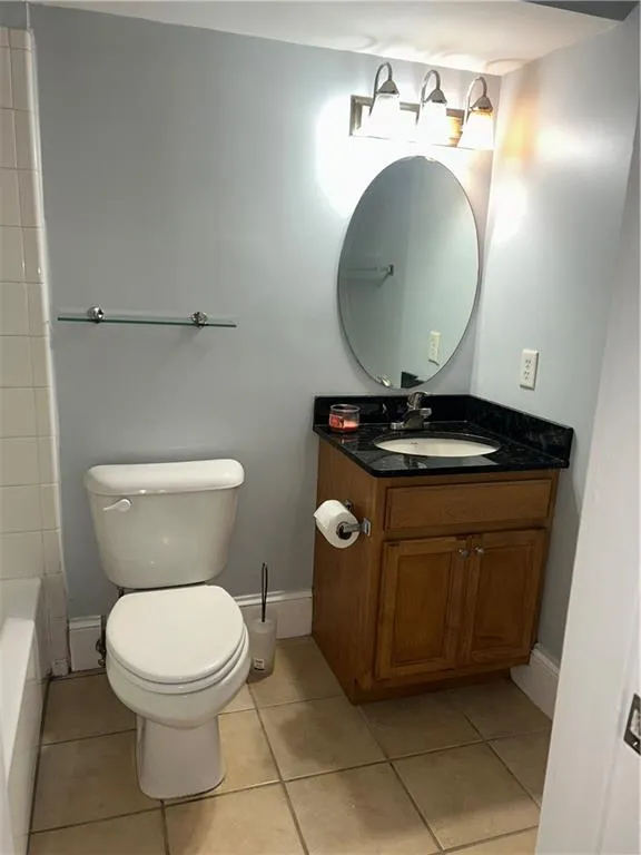 Full bathroom featuring vanity, toilet, and tile patterned flooring