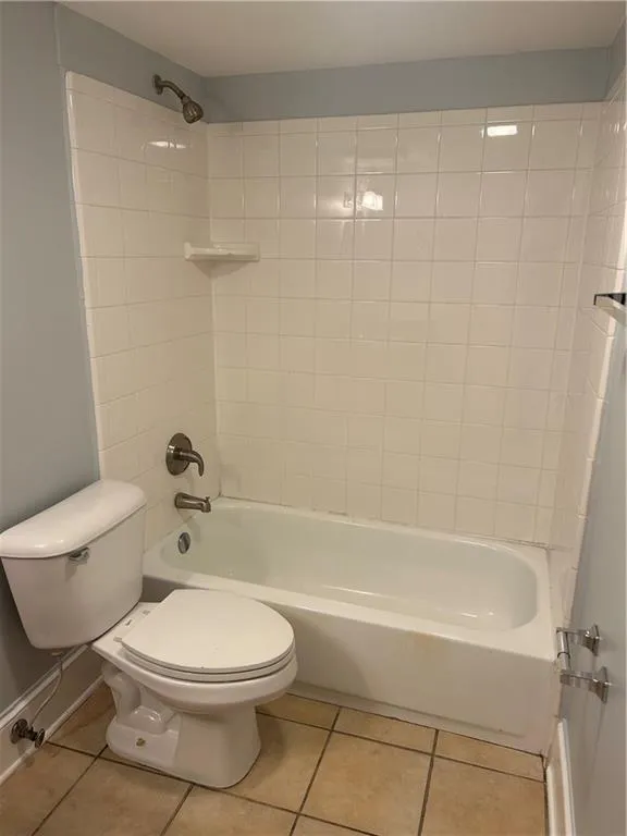 Bathroom with tile patterned flooring, toilet, and  shower combination