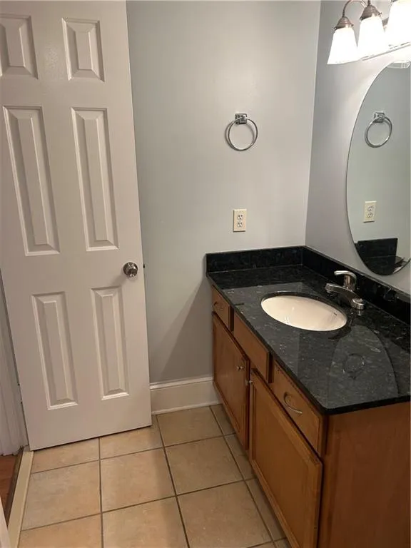 Bathroom featuring vanity, tile patterned flooring, and baseboards
