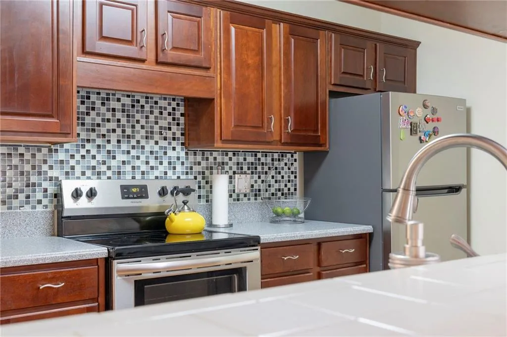 Kitchen featuring tasteful backsplash and appliances with stainless steel finishes