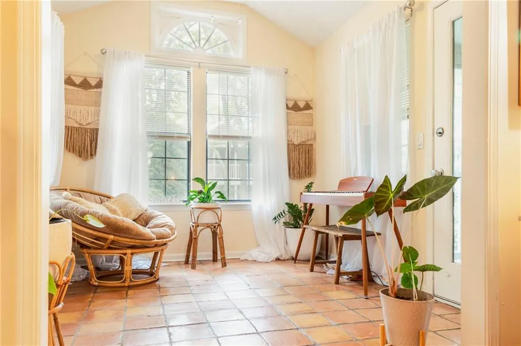 Sitting room with light tile patterned floors and vaulted ceiling