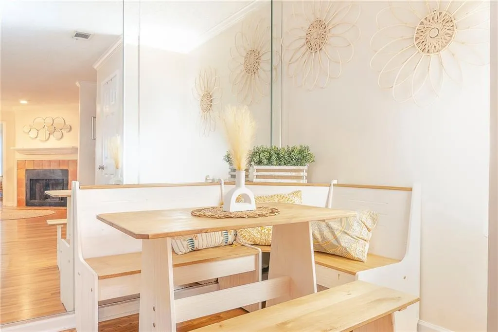 Dining space with a fireplace, wood-type flooring, and ornamental molding