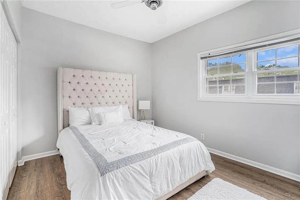Bedroom with wood finished floors, ceiling fan, and a closet