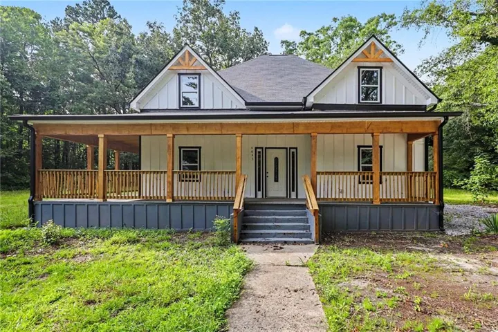 White board-and-batten exterior with contrasting dark trim and a dark roof