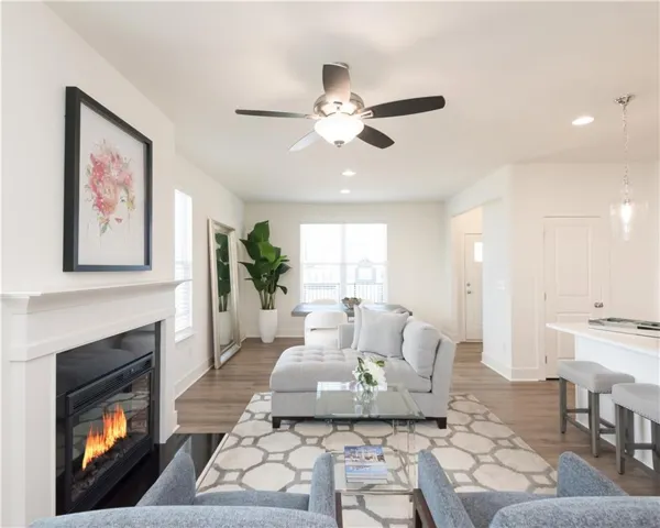 Bright open-concept living space featuring wood-finish flooring, a contemporary ceiling fan, and recessed lighting