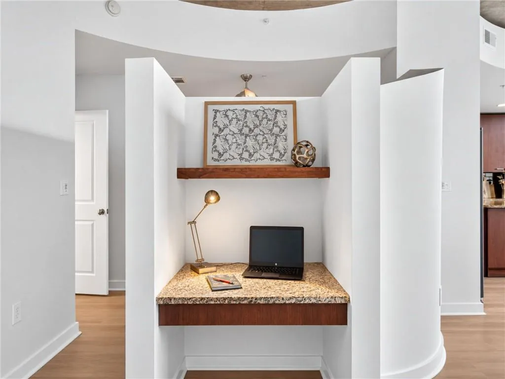 Built-in desk featuring a granite countertop, wood-finish shelving, and integrated wood-finish cabinetry