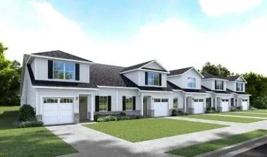 Row of townhomes featuring light-colored siding, black shutters, and single-car garages