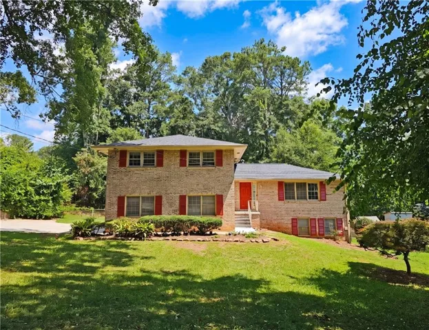 Brick residence with red shutters and a red entry door