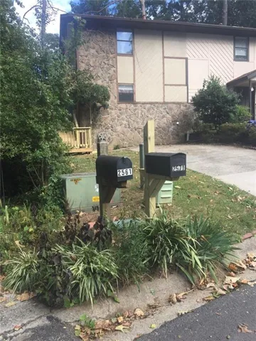 Stone veneer and siding exterior with mature landscaping