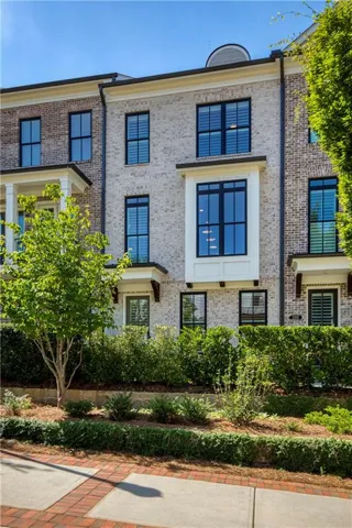 Brick exterior with contrasting light brick facade, black-framed windows, and a prominent bay window feature