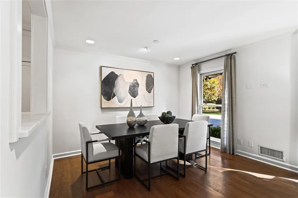 Dining room with dark wood-style floors, ornamental molding, and recessed lighting