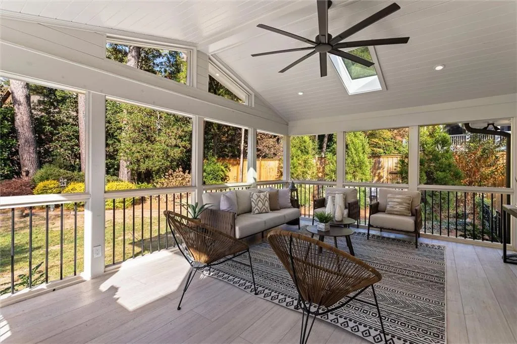 Sunroom with ceiling fan, lofted ceiling, a skylight, and an outdoor living space