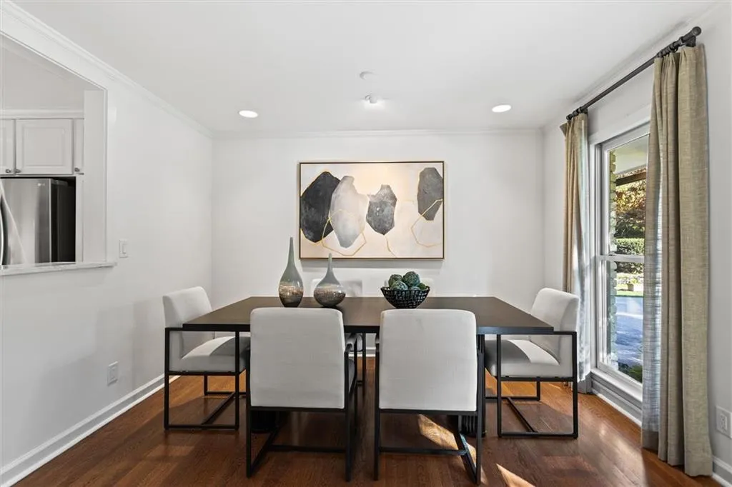 Dining room featuring dark wood-style floors, crown molding, and recessed lighting