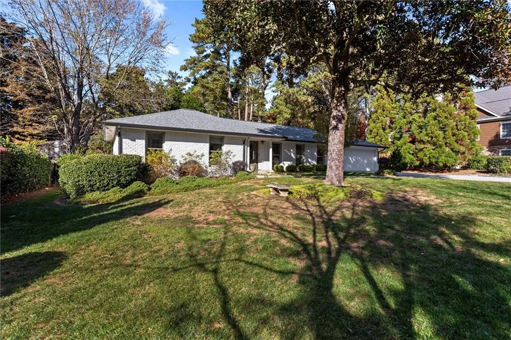 Ranch-style house featuring a front lawn and brick siding