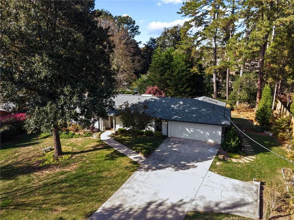 View of front of home with concrete driveway, a front yard, and a garage