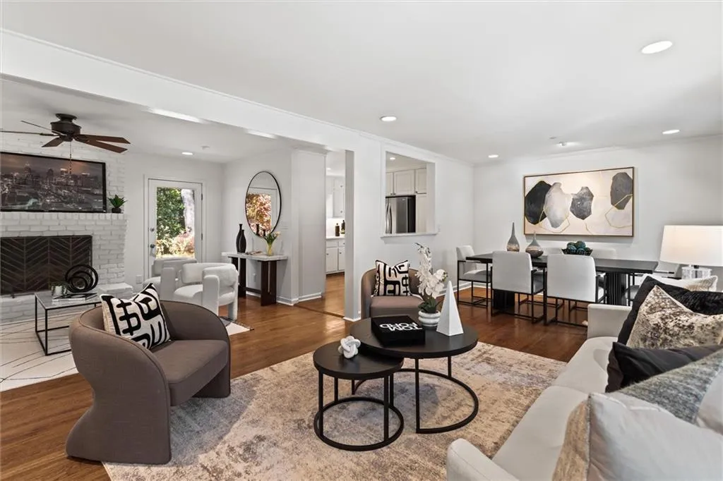 Living room with wood finished floors, a fireplace, recessed lighting, and ceiling fan