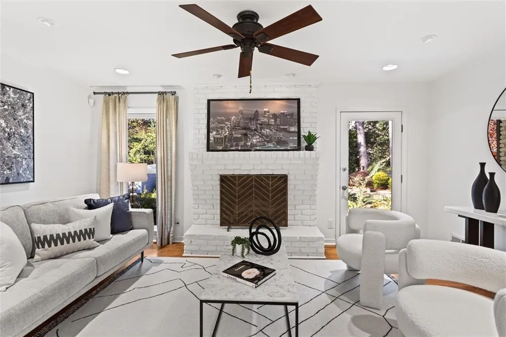 Living room with a brick fireplace, wood finished floors, healthy amount of natural light, a ceiling fan, and recessed lighting