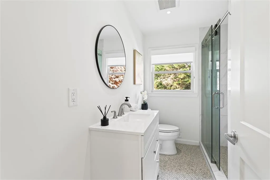 Full bath with light tile patterned floors, a shower stall, and vanity