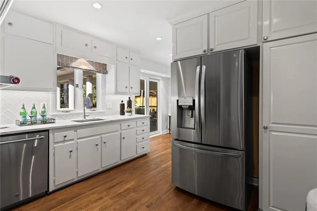 Kitchen featuring white cabinets, stainless steel appliances, recessed lighting, dark wood-style floors, and tasteful backsplash