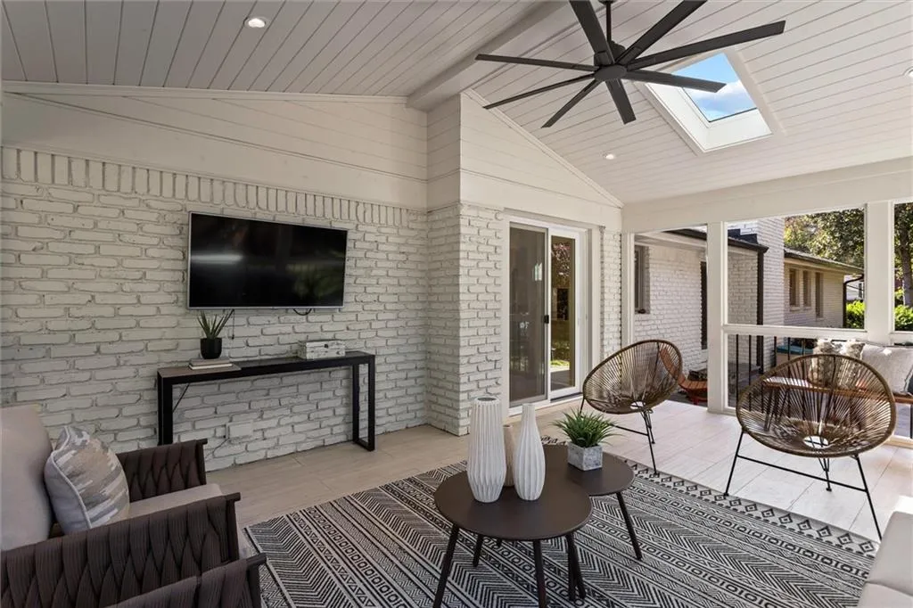 Sunroom / solarium featuring vaulted ceiling, brick wall, a skylight, wood ceiling, and wood finished floors