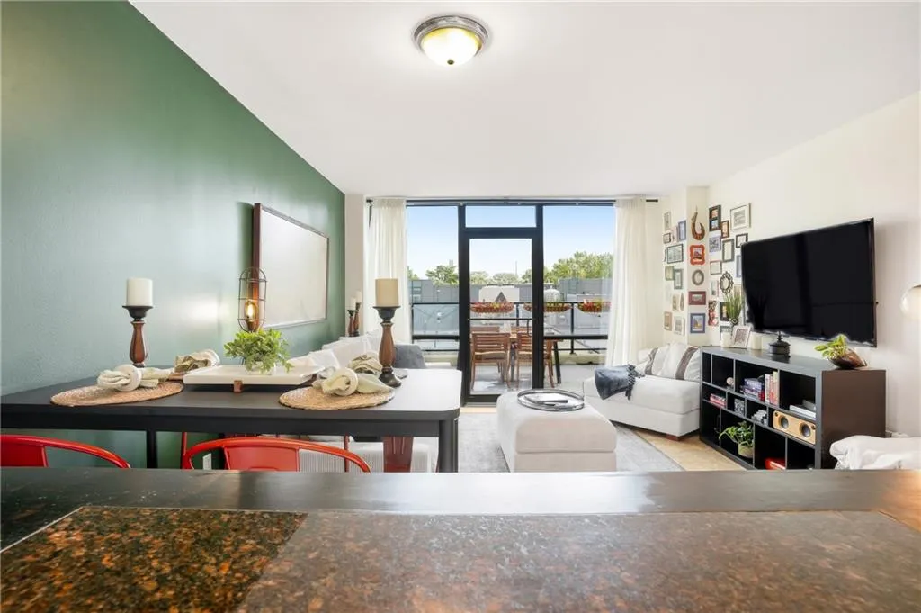 Living area with open dining area featuring a wall of windows for lots of natural light.