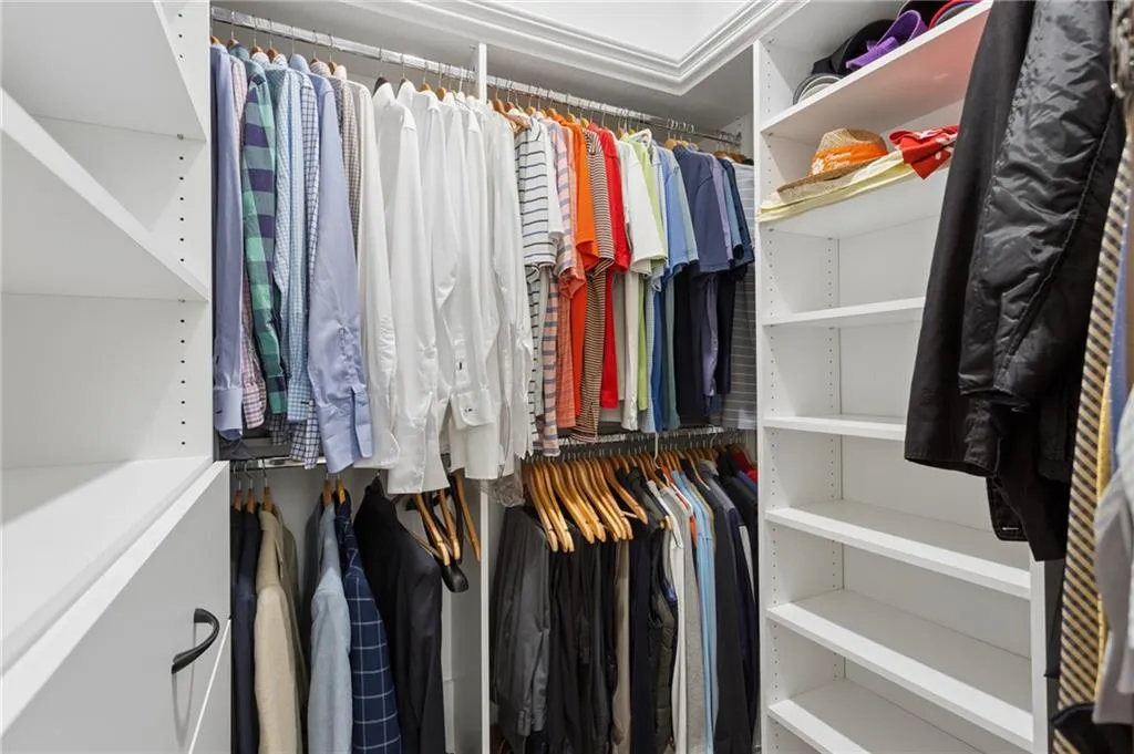 Walk-in closet with ample storage featuring custom built-in shelving