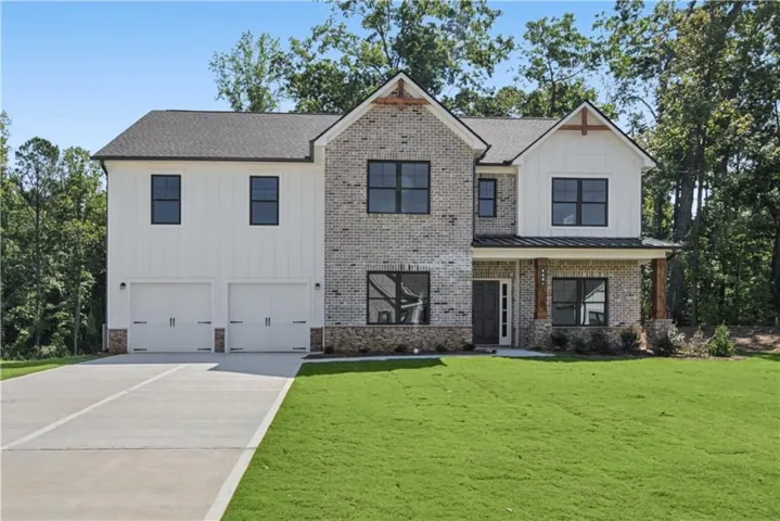 Modern farmhouse exterior featuring board and batten siding, brick accents, and a covered entry