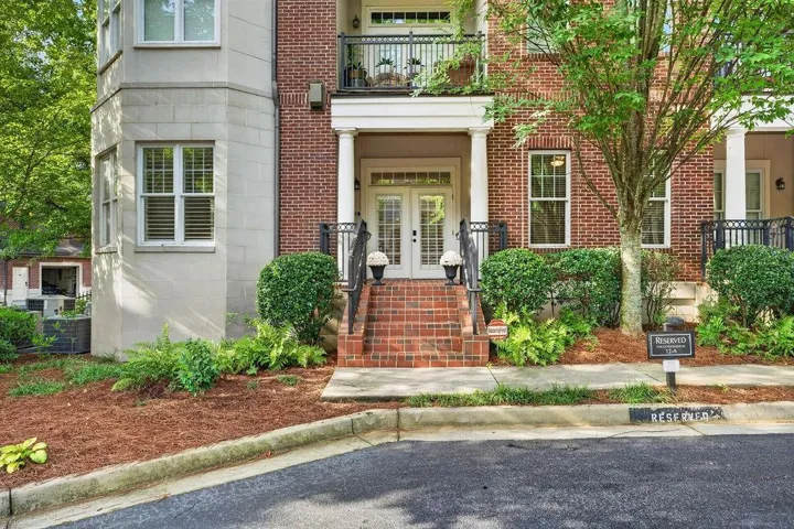 Brick exterior with stone accents, covered entry, and a balcony with wrought iron railing