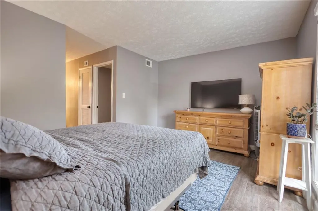 Bedroom with wood finished floors and a textured ceiling
