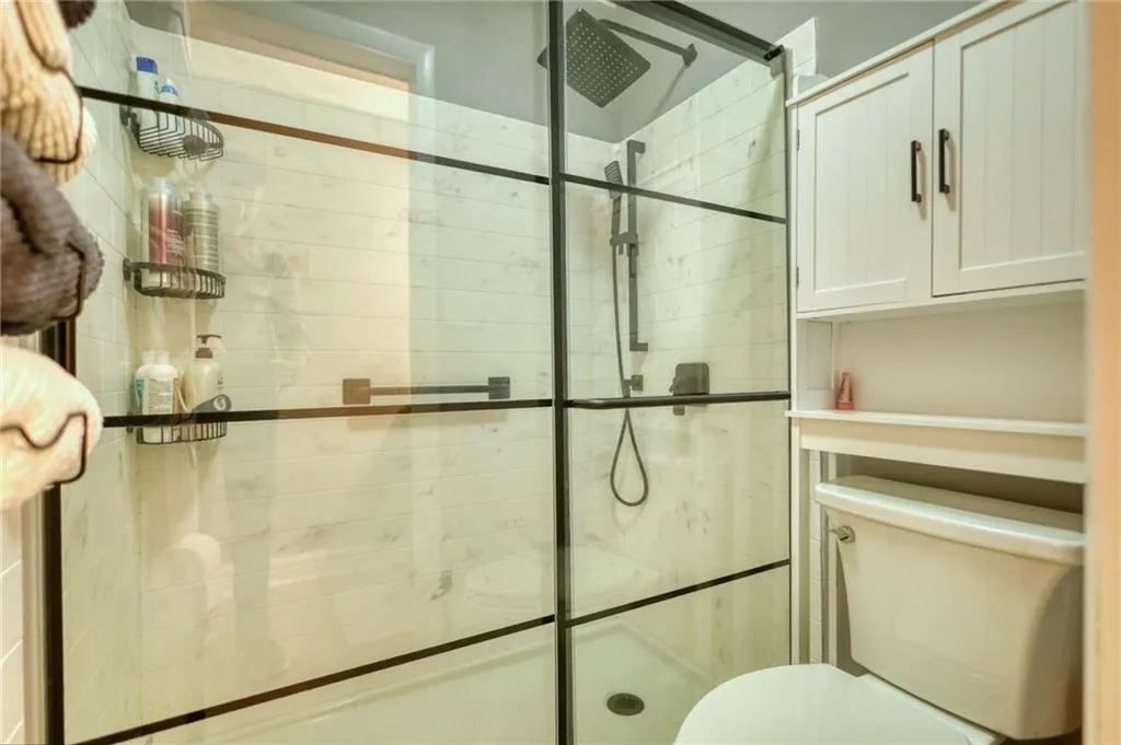 Full bathroom with a stall shower and toilet