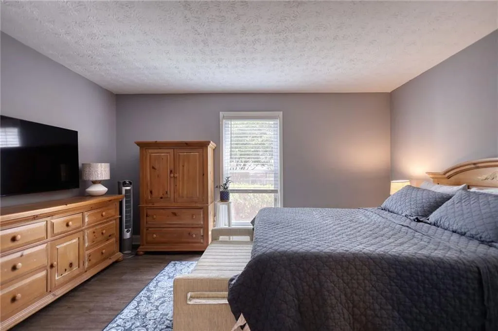 Bedroom featuring dark wood-type flooring and a textured ceiling