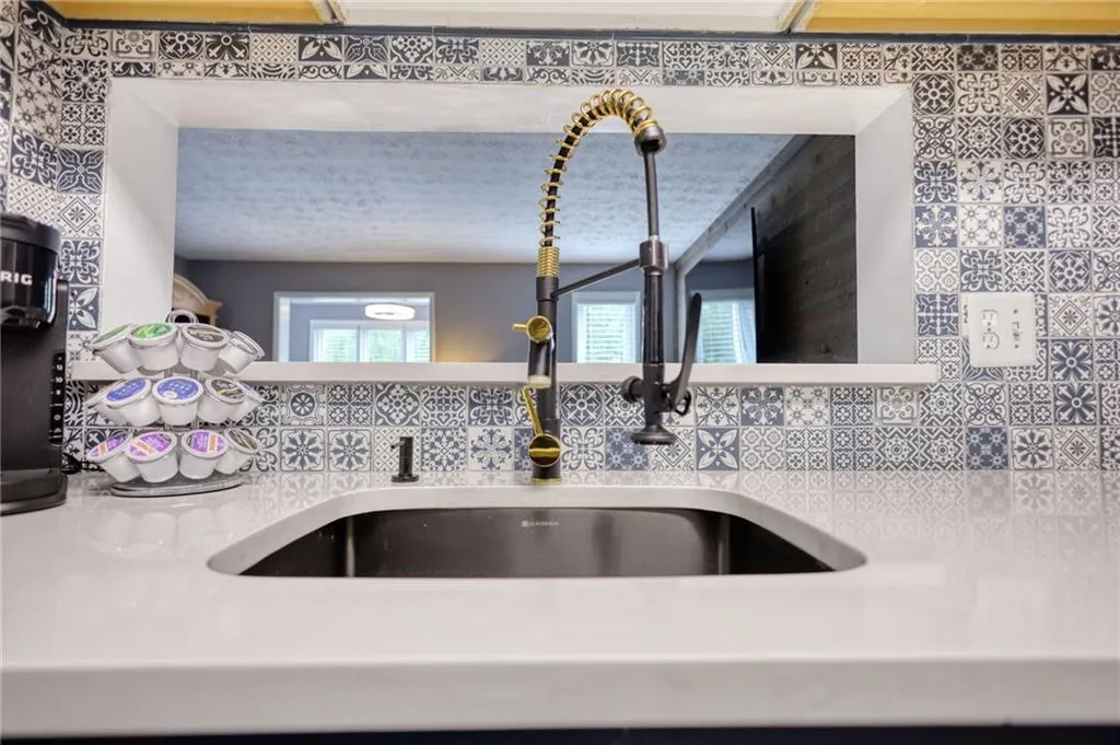 Kitchen view of a sink and light stone countertops