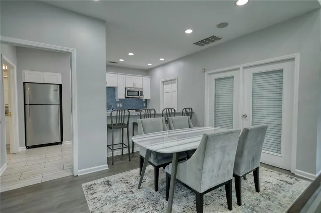 Dining room with light wood-style floors and recessed lighting