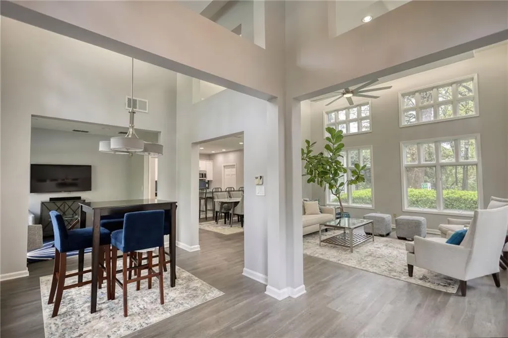 Dining space featuring a towering ceiling, wood finished floors, ceiling fan, and recessed lighting
