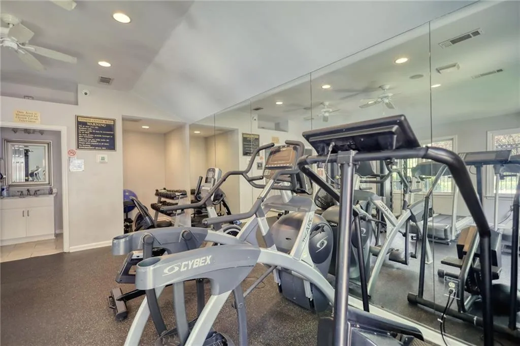 Workout area with a ceiling fan, lofted ceiling, and recessed lighting
