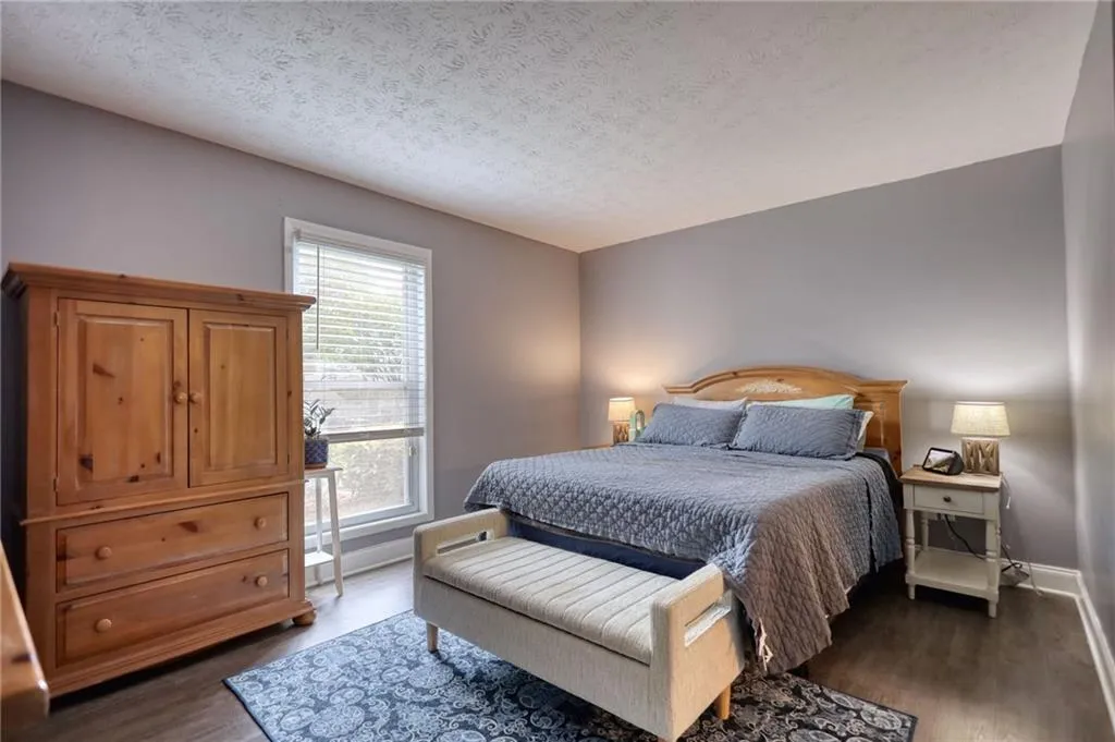 Bedroom with dark wood-type flooring and a textured ceiling