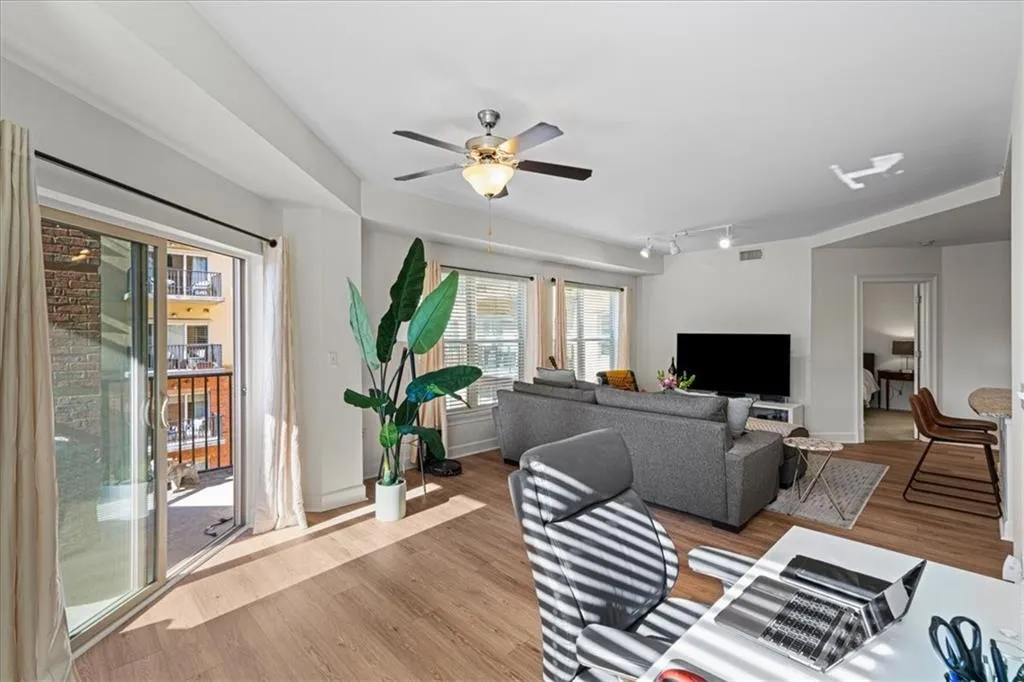 Living room with ceiling fan, rail lighting, and light wood-type flooring