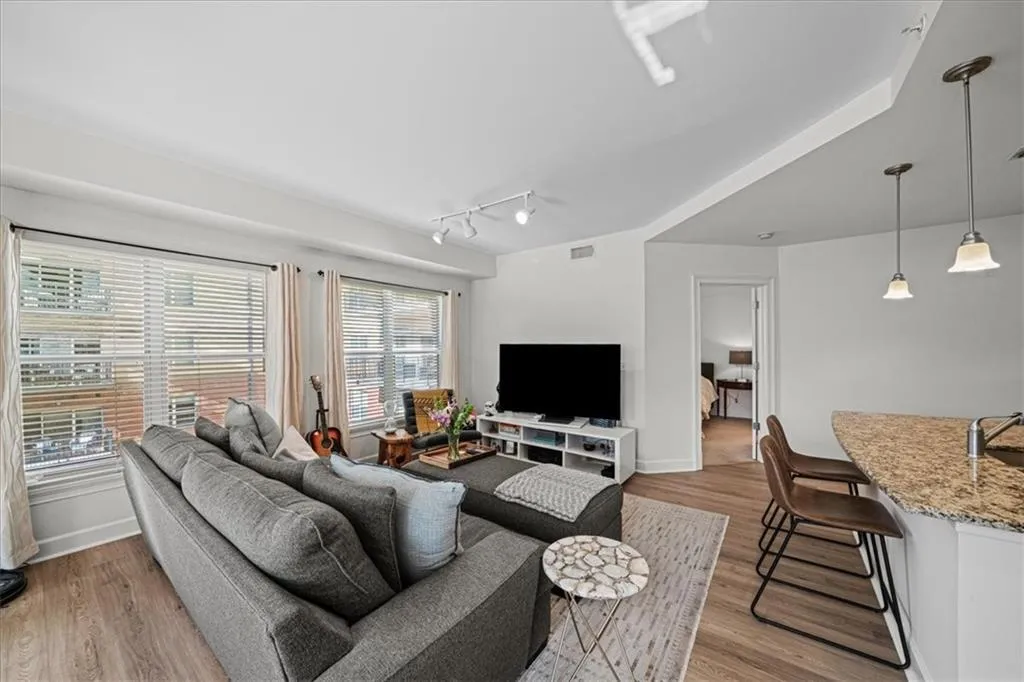 Living room with light hardwood / wood-style flooring, plenty of natural light, and sink