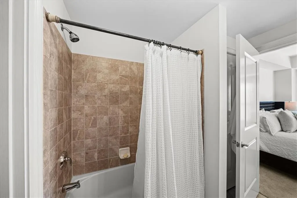 Bathroom with shower / bath combination with curtain