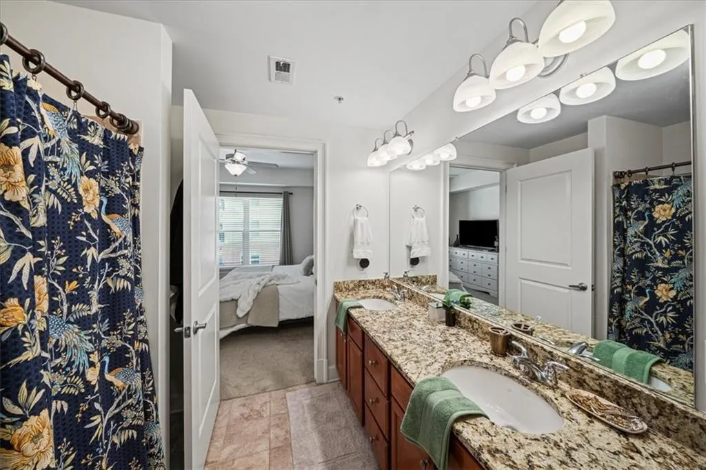 Bathroom with vanity, tile patterned floors, and ceiling fan